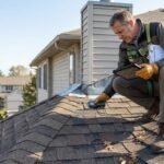 Professional roofing inspector examining asphalt shingles during a residential roof inspection.