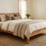 A well-made bed showcasing a wooden frame and a clean white bedspread.